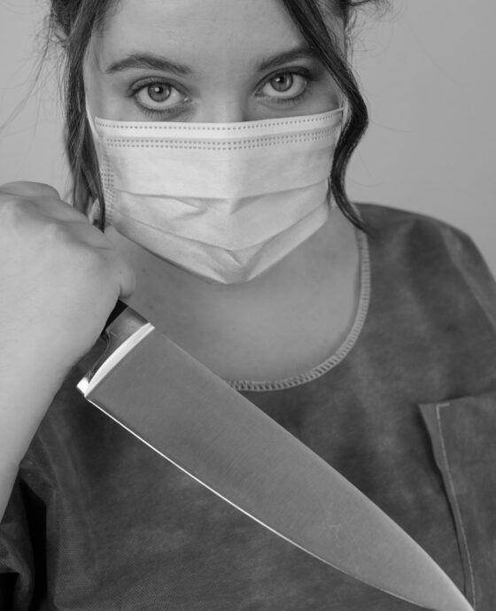 A masked person holds a knife.