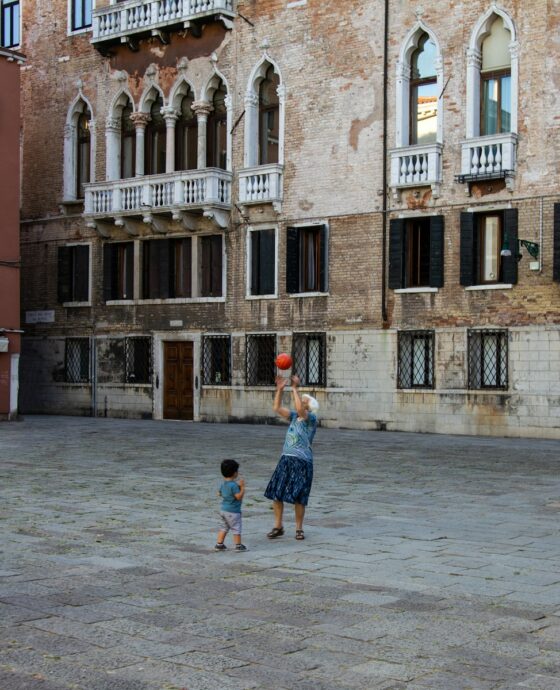 woman playing with child using basketball