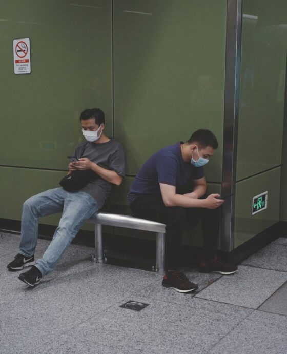 man in blue crew neck t-shirt sitting on white plastic chair