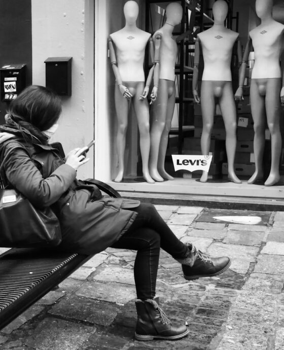 grayscale photo of woman in black bikini sitting on bench