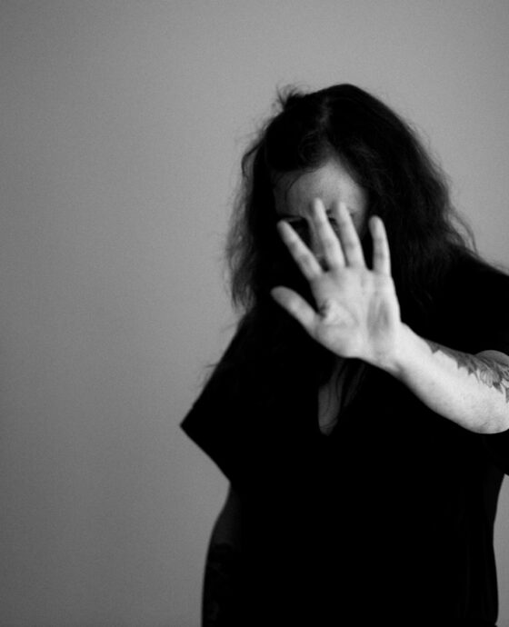 grayscale photo of woman covering her face with her hands