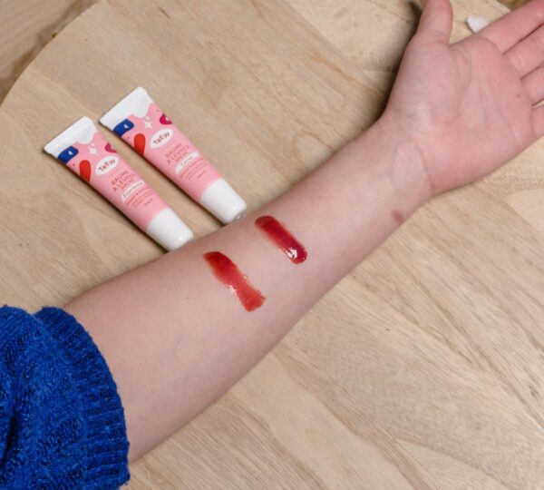 a person's arm with three tubes of lipstick on it