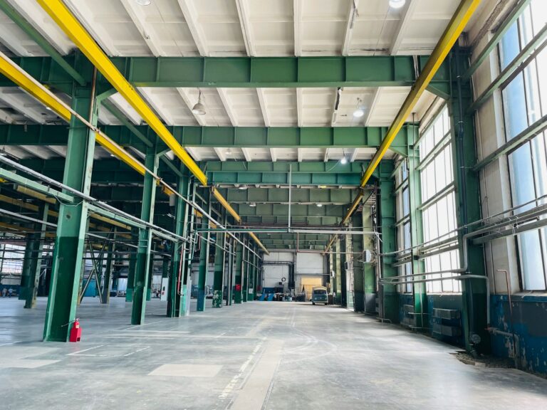 an empty warehouse with yellow and green pipes