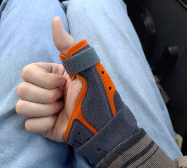 A thumb brace shows a thumbs-up gesture.