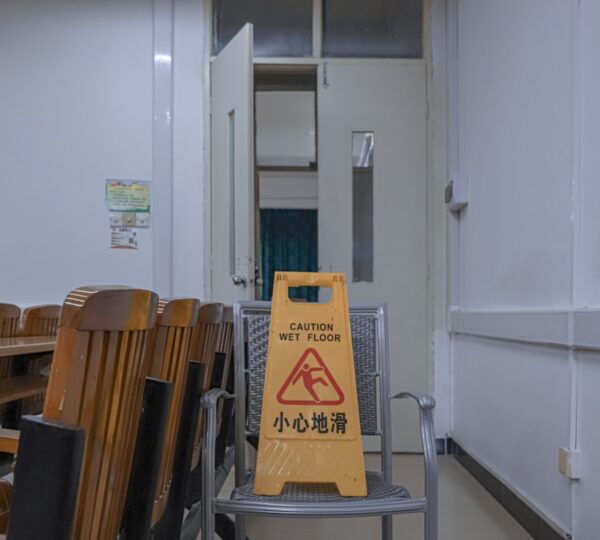 a yellow caution sign sitting on top of a metal chair